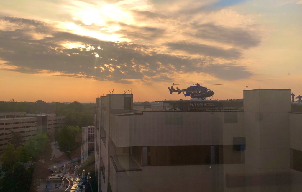 Hospital skyline with sunrise and helicopter.